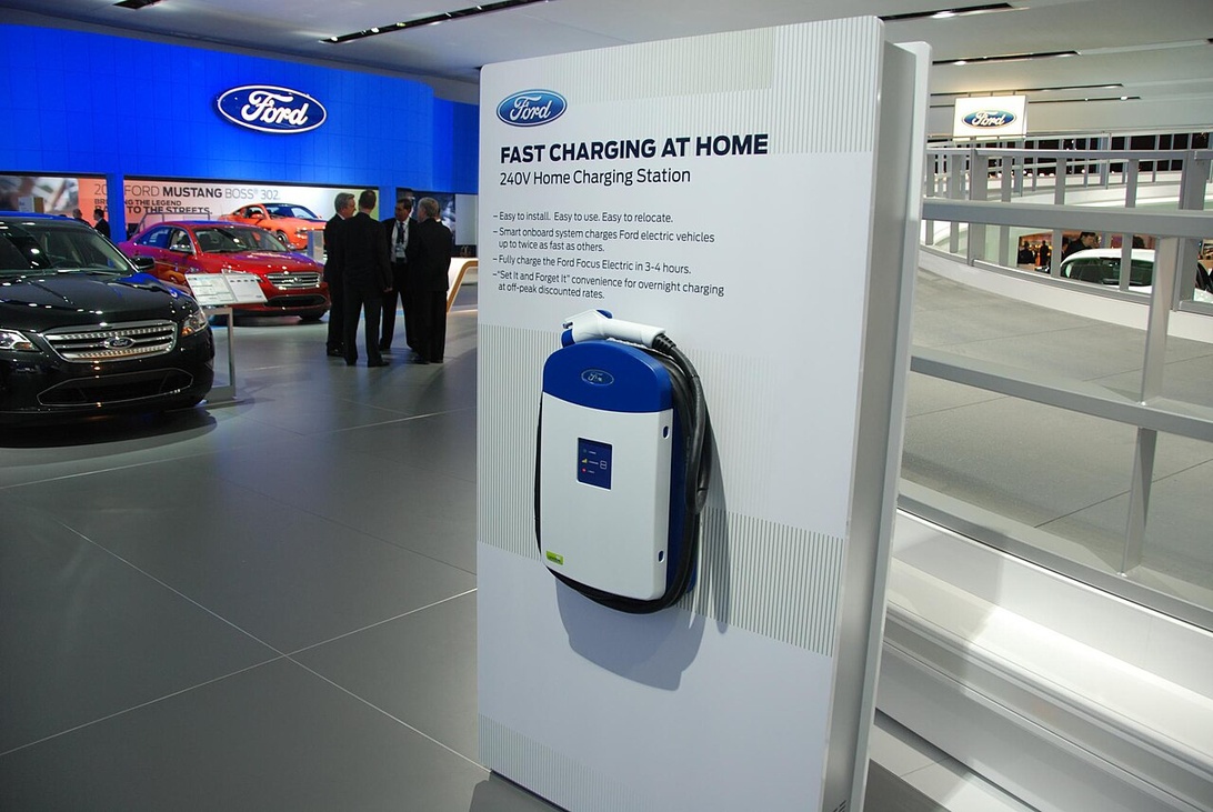 En vægmonteret ladeboks fra Ford udstillet med specifikationer om hurtig hjemmeopladning.